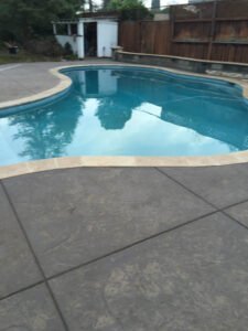 Curved backyard swimming pool at twilight.
