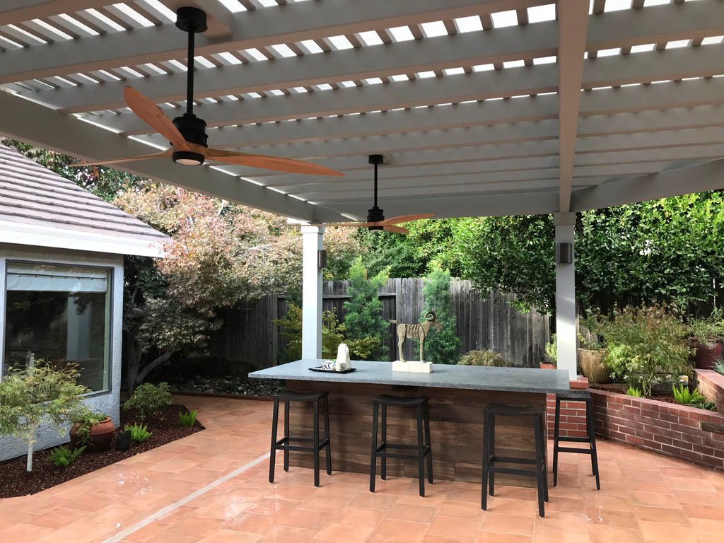 Spacious outdoor patio with overhead pergola and ceiling fans.