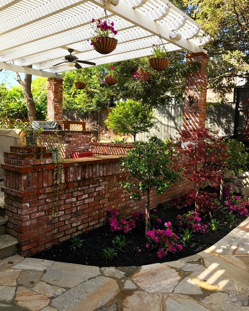 Charming garden patio with pergola and hanging flower baskets.
