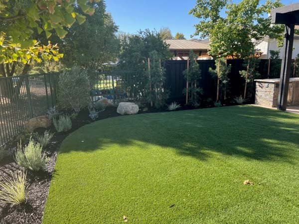Lush backyard garden with artificial grass and wooden fence