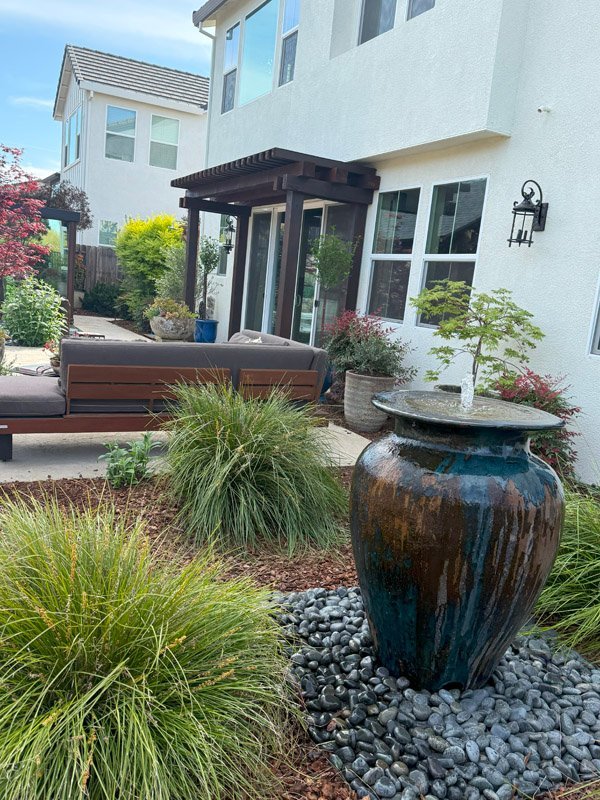 South Canyon Construction creates a modern outdoor space featuring a decorative fountain landscaping