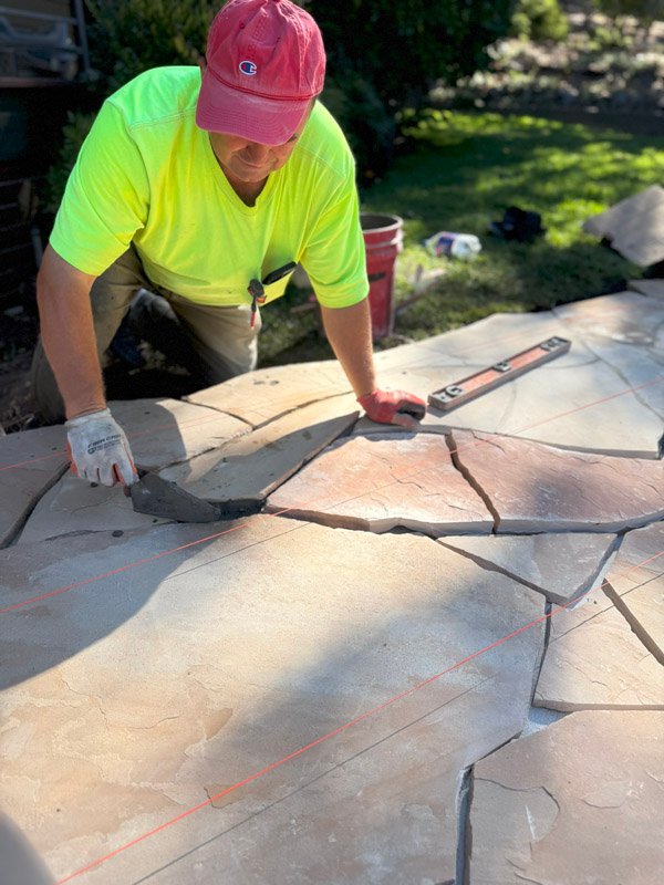 Viktor placing stone pavers at a South Canyon Construction job site