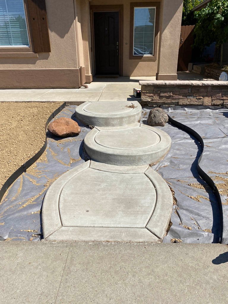 Curved concrete pathway leading to front door.