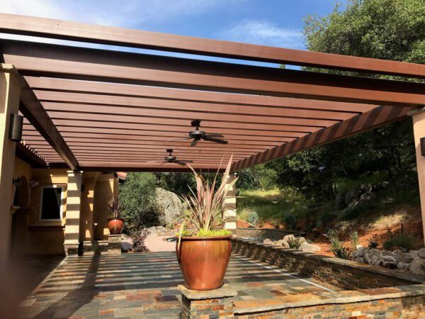 Wooden pergola over patio with large potted plant