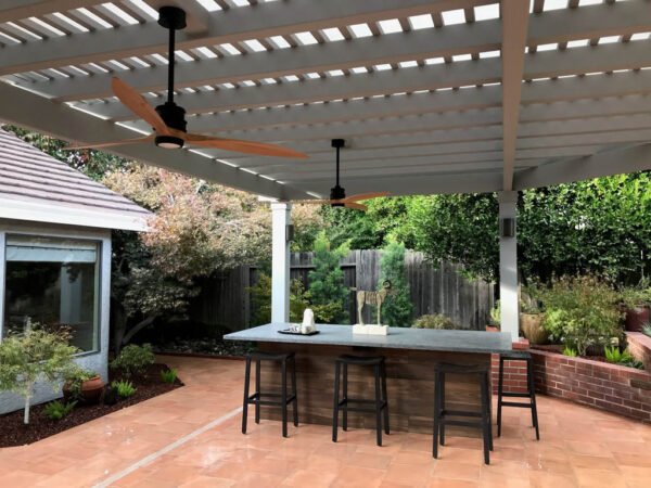 Outdoor patio with pergola, fans, and modern bar seating