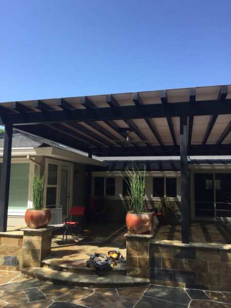 Patio with pergola, seating area, and potted plants