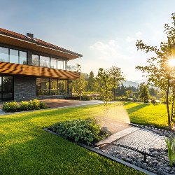 Modern house with lush garden at sunset