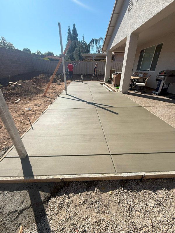 New concrete patio installation by South Canyon Construction in sunny backyard