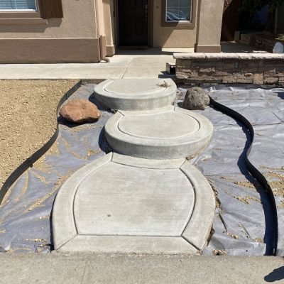 Curved concrete pathway leading to front door.