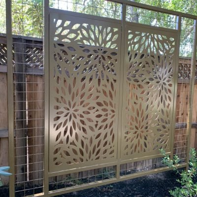 Decorative metal garden screen with floral cut-outs.