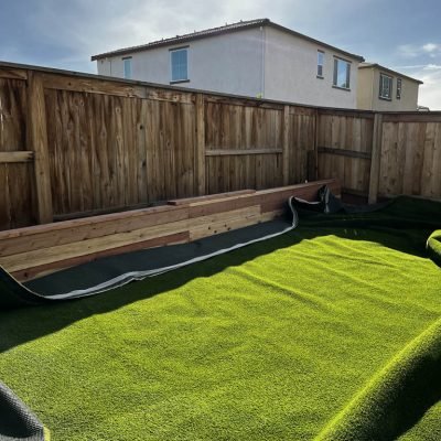 Backyard with artificial turf and wooden fence.