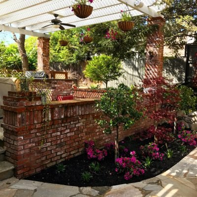 Charming garden patio with pergola and hanging flower baskets.