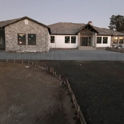 Newly constructed house at dusk with paved front yard.